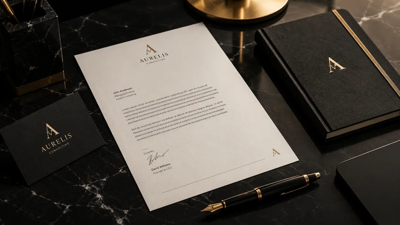 Premium brand identity stationery showing consistent typography across a letterhead, business card and notebook